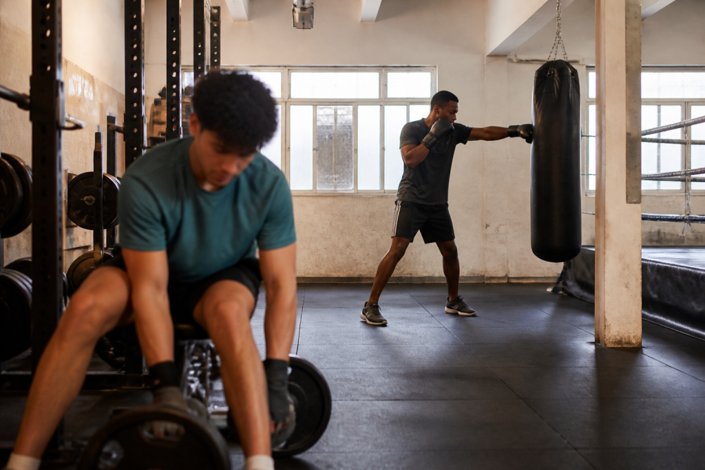 Personnes effectuant musculation et boxe dans une salle